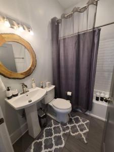 ein Badezimmer mit einem Waschbecken, einem WC und einem Spiegel in der Unterkunft West End Modern Atlanta 3 Bedroom Bungalow in Atlanta