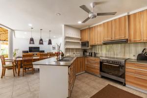 a kitchen with wooden cabinets and a table with chairs at Elina Villas in Seminyak