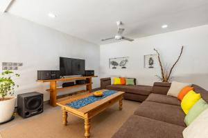 a living room with a couch and a tv at Elina Villas in Seminyak