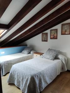 1 dormitorio con 2 camas en una habitación en Apartamentos LLave de Santillana, en Santillana del Mar