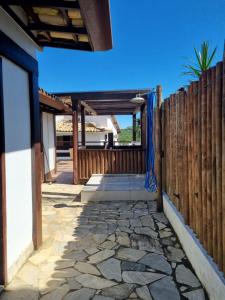 a patio with a fence and a stone walkway at Casa Aprazível no Alto de Búzios in Búzios