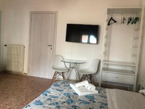 a room with a bed and a table and a tv at Bed a Cavour in Gaeta