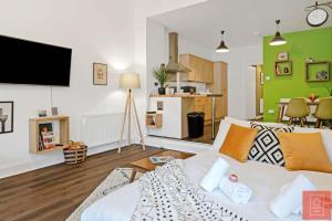 sala de estar con sofá blanco y cocina en Cheerful Stays: Spacious Flat in Vibrant Leith en Edimburgo
