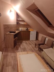 an attic kitchen with a counter and a kitchen with a counter at Agrohaczow za rzeką in Haczów