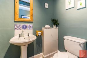 y baño con lavabo, aseo y espejo. en Cheerful Stays: Spacious Flat in Vibrant Leith en Edimburgo