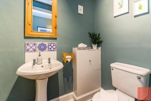 a bathroom with a sink and a toilet and a mirror at Cheerful Stays: Spacious Flat in Vibrant Leith in Edinburgh