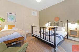 Un dormitorio con 2 camas y una silla. en Cheerful Stays: Spacious Flat in Vibrant Leith en Edimburgo