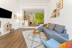 sala de estar con sofá azul y mesa en Cheerful Stays: Spacious Flat in Vibrant Leith en Edimburgo