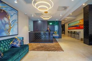 a lobby with a green couch in front of a bar at The Sebel Wellington Thorndon in Wellington