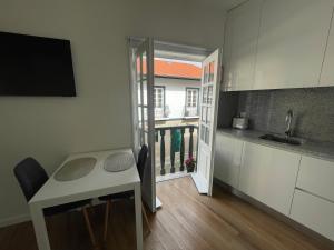 a small kitchen with a table and a counter top at RETIRO 401 one-bedroom apartment in Guimarães