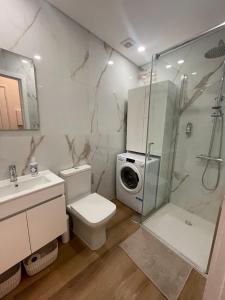 a bathroom with a shower and a toilet and a sink at RETIRO 401 one-bedroom apartment in Guimarães