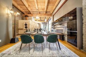a kitchen with a table and two green chairs at Historic JD Loft, Near ICE District, Rogers Place, UG Parking in Edmonton