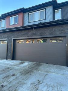 uma casa com uma porta de garagem em frente em Brand new 1 Bedroom Basement Suite. Wi-Fi,Netflix em Edmonton