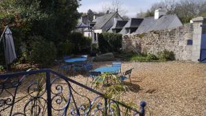 a patio with blue tables and chairs and a wall at Maison Castel Braz in Pont-Aven