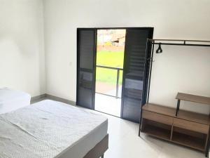 a bedroom with a bed and a sliding glass door at Sobrado 2 com Jacuzi e Churrasqueira in Brotas