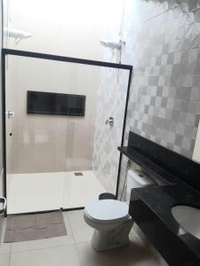 a bathroom with a toilet and a shower and a sink at Sobrado 2 com Jacuzi e Churrasqueira in Brotas