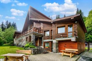 a wooden house with a picnic table in front of it at Chata pod Sedlom Čertovica in Liptovská Sielnica
