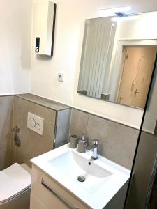 ein Badezimmer mit einem Waschbecken, einem Spiegel und einem WC in der Unterkunft Modern & Schick in Hannover