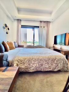 een slaapkamer met een groot bed en een groot raam bij Magnifique appartement Résidence DOMAINE DE NORIA in Marrakesh