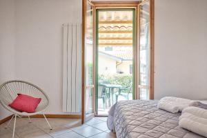 a bedroom with a bed and a chair and a balcony at Appartamento - Il Chicco in Sinalunga