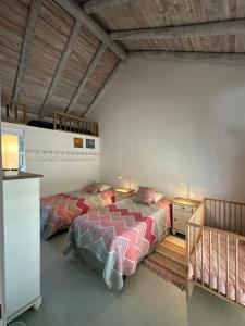 um quarto com 2 camas e uma escada em Casas na Lagoa - Carvalhal no Carvalhal