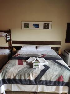 um quarto com uma cama com duas toalhas em Pousada Natureza e Arte em Cunha
