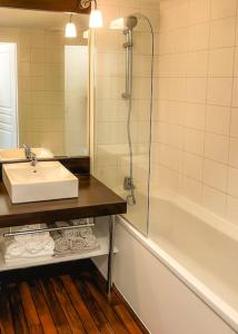 a bathroom with a sink and a shower and a tub at Eleni appart 4p à Richelieu in Chaveignes