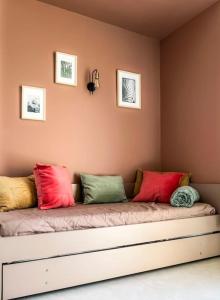 a couch with colorful pillows on it in a room at Eleni appart 4p à Richelieu in Chaveignes +7 photos