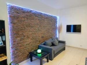 a brick wall in a living room with a couch at Ideal 3 ambientes c/ homeoffice. Palermo-V.Crespo in Buenos Aires