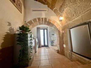 a bathroom with an archway in a building with a plant at The love barrel, lovely one bedroom in Parabita in Parabita