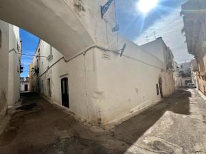 an alley with a white building with an archway at The love barrel, lovely one bedroom in Parabita in Parabita
