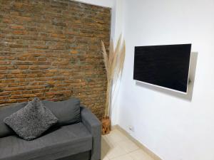 sala de estar con sofá y pared de ladrillo en Ideal 3 ambientes c/ homeoffice. Palermo-V.Crespo en Buenos Aires