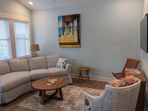 a living room with a couch and a table at Salty Kisses - Let The Beach Reconnect Your Souls in Corolla