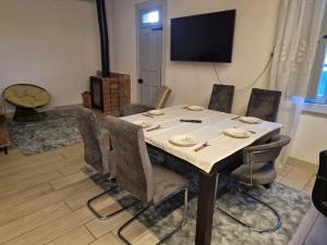 a table in a room with chairs and a television at A Casa da Lúa in Nieves