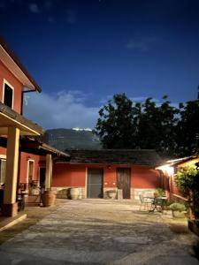 un patio de un edificio rojo por la noche en B&B Colle Cucchiara, en Cassino