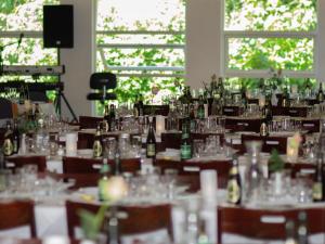una stanza piena di tavoli con bicchieri e bottiglie di Orø Kro & Hotel a Orø
