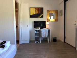Zimmer mit einem Schreibtisch, einem TV und einem Bett in der Unterkunft Orø Kro & Hotel in Orø