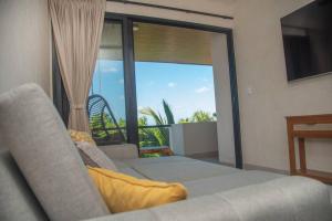 a living room with a couch and a large window at Micaela Bacalar C2 Depto de lujo Vista Laguna in Bacalar