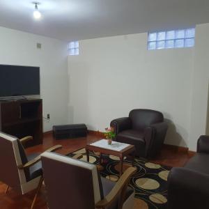 a living room with couches and a table and a tv at Departamento céntrico - 3 habitaciones in Sucre