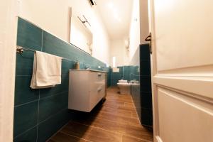 bagno con piastrelle verdi e servizi igienici bianchi di A Casa di Titto guest house a Napoli