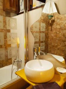 y baño con lavabo amarillo y bañera. en Claustro Home Casco Histórico Córdoba, en Córdoba