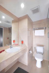 a bathroom with a toilet and a sink at favehotel Jababeka Cikarang in Cikarang