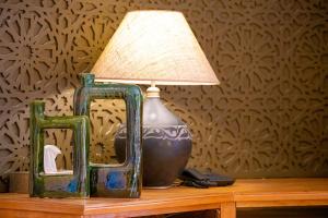 a lamp sitting on a table next to a mirror at Palais Mirage d'Atlas - Restaurant & Spa & Day Pass in Marrakesh