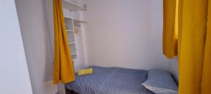 1 dormitorio pequeño con 1 cama y cortinas amarillas en MAIRIE, Apart 50 m2 , Lumineux , Rénové , 4 Pers., en Le Havre