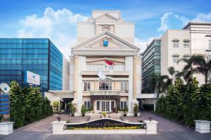 a large white building with a flag on it at Blue Sky Pandurata Hotel Cikini in Jakarta