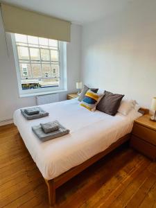 a bedroom with a large white bed with a window at Cosy London bedroom near Oval Station - shared bathroom in London