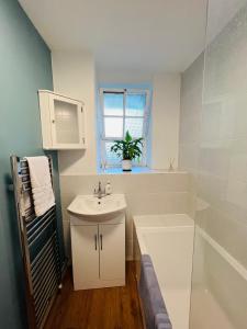 biała łazienka z umywalką i prysznicem w obiekcie Cosy London bedroom near Oval Station - shared bathroom w Londynie