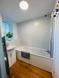 a bathroom with a bath tub and a sink at Cosy London bedroom near Oval Station - shared bathroom in London