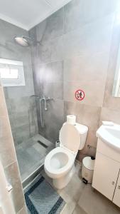 a bathroom with a toilet and a shower and a sink at Blue and White in Kremasti