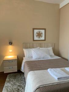 a bedroom with two beds and a nightstand and a bed sidx sidx sidx sidx at Renace Suites in Tacna